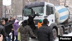 Armenia - Environmental activists stop a truck delivering concrete to a construction site in a central Yerevan park, 17Feb2012.