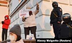 A woman holds a sign reading "Putin is a murderer" during a rally in support of Navalny in Omsk on April 21.