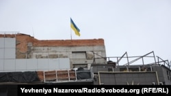 Національний прапор на будівлі закритого ТРЦ, який був пошкоджений ракетним ударом у 2022 році