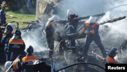 Russian emergency workers carry the burned body of a victim from the debris of a psychiatric hospital destroyed by fire.