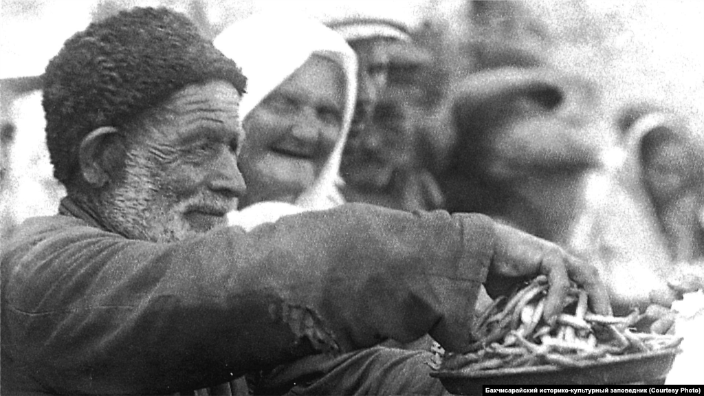 A man sells beans in Bakhchysaray. Beans were a part of the cuisine in all regions of Crimea. Possible dishes were a meat soup with green beans seasoned with sour milk, noodle soup with boiled beans, or just beans served with noodles