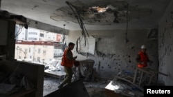 Израелски војници ги проверуваат остатоците од стан погоден во смртоносен ирански ракетен напад во Рамат Ган, надвор од Тел Авив, на 18 март 2026 година