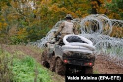 Узьвядзеньне агароджы з калючага дроту на мяжы Латвіі і Беларусі, верасень 2021 году