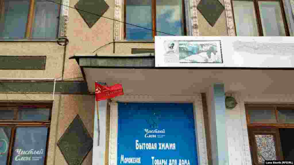 Над входом у магазин на вулиці Леніна &ndash; символіка колишнього колгоспу &laquo;Пам&#39;ять Леніна&raquo; і прапор, що залишився після святкування 9 травня