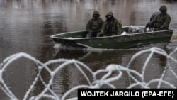 Polish soldiers patrol at the border with Belarus on the Bug River, near Slawatycze, in eastern Poland on December 7.