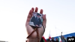 Людина тримає в руках фото іранського верховного лідера аятоли Алі Хаменеї, який загинув під час спільних ударів США та Ізраїлю. Тегеран, 1 березня 2026 року