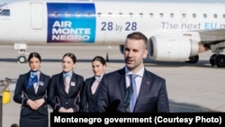 Premijer Milojko Spajić ispred brendiranog aviona sa porukom o pristupanju EU, 25. februar 2026.