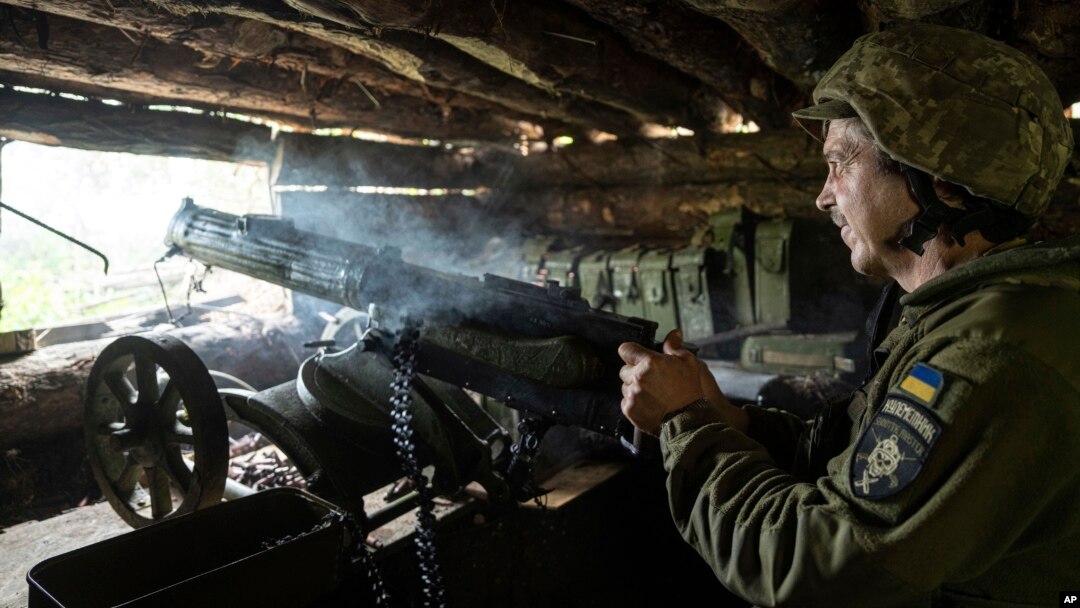Un militar ucrainean din brigada 28 trage cu o mitralieră cu recul Maxim în direcția pozițiilor rusești de pe linia frontului din regiunea Donețk, Ucraina, 21 iunie 2023.