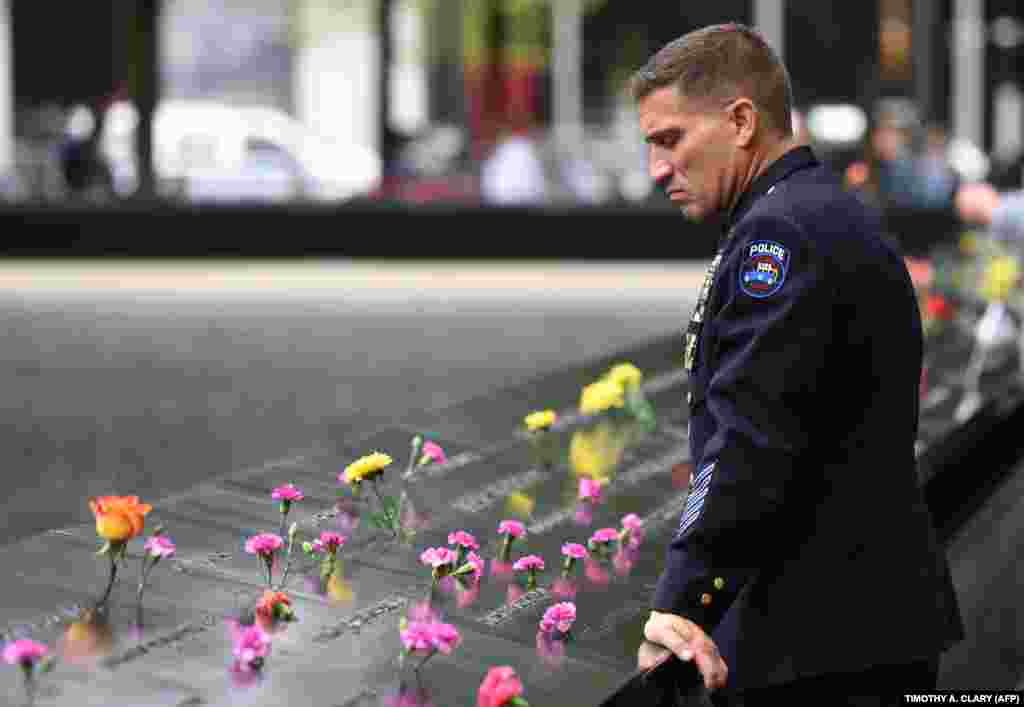 A Port Authority police officer looks down into the South Pool during observances on September 11 held on the 17th anniversary of the September 11, 2001, terror attacks at the annual ceremony at the Ground Zero memorial site in New York City. (AFP/Timothy A. Clary)