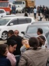 Refugees wait after crossing the border and arriving at a registration centre of the Armenian foreign affairs ministry, near the border town of Kornidzor, on September 25, 2023.