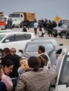 Refugees wait after crossing the border and arriving at a registration centre of the Armenian foreign affairs ministry, near the border town of Kornidzor, on September 25, 2023.