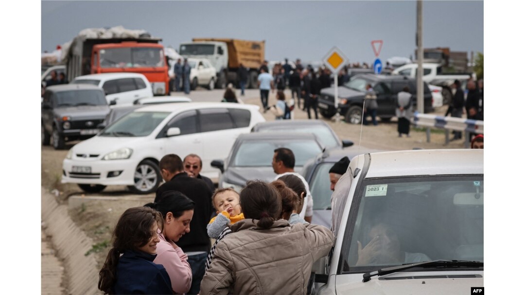 Refugiații așteaptă după ce au trecut granița și au ajuns la un centru de înregistrare al ministerului armean de externe, lângă orașul de graniță Kornidzor, pe 25 septembrie 2023.