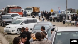 People fleeing from Nagorno-Karabakh wait after crossing the border into Armenia and arriving at a registration center on September 25. 