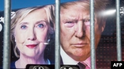 Images of Democratic nominee Hillary Clinton (left) and Republican nominee Donald Trump are seen behind a security fence where they debated in New York.