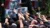 Mourners try to touch the flag-draped caskets of President Ebrahim Raisi, Foreign Minister Hossein Amir-Abdollahian, and Raisi's chief bodyguard, Mehdi Mousavi, during a funeral ceremony in the city of Tabriz, Iran, on May 21. 