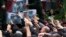 Mourners try to touch the flag-draped caskets of President Ebrahim Raisi, Foreign Minister Hossein Amir-Abdollahian, and Raisi's chief bodyguard, Mehdi Mousavi, during a funeral ceremony in the city of Tabriz, Iran, on May 21. 