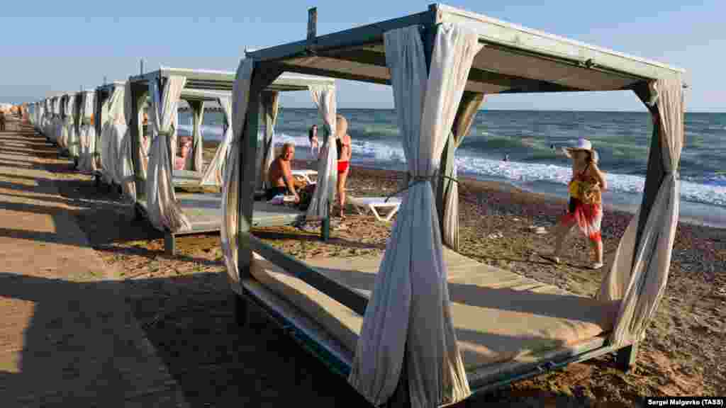 На пляже туристам предлагают разместиться в таких шатрах