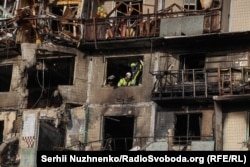 Emergency crews work at a residential building in Kyiv after a massive Russian air attack early on November 14.