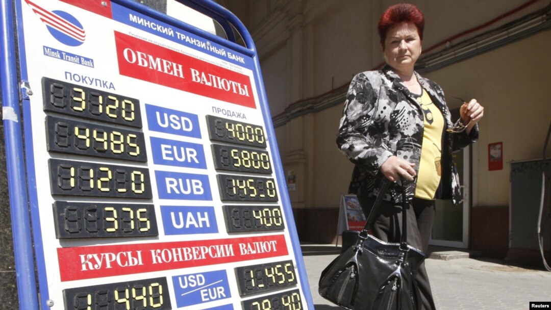 A woman passes by a currency exchange office in the Belarusian capital, Minsk