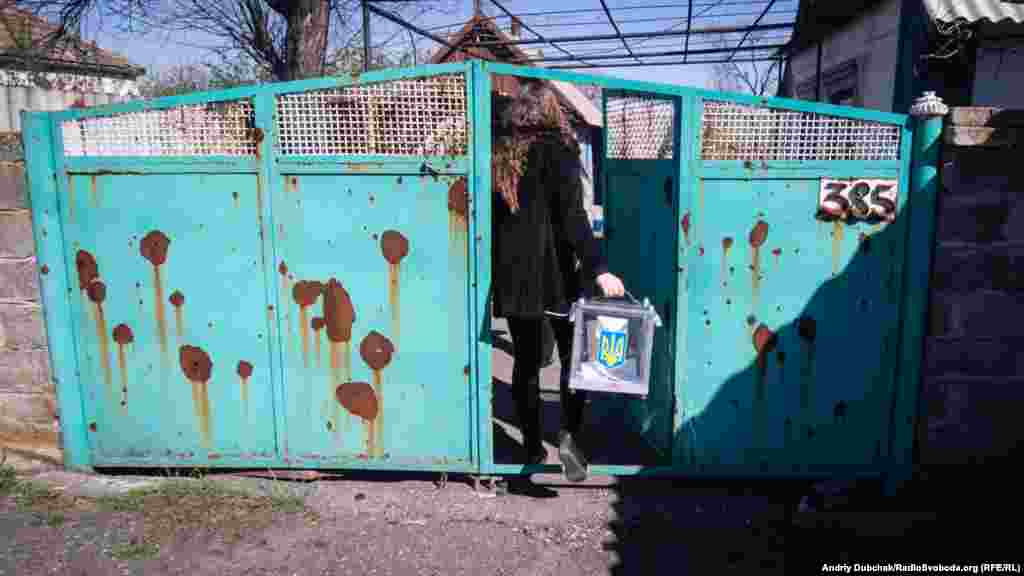 Член избирательной комиссии приносит урну для голосования в Новотроице &ndash; село на линии огня в Донецкой области. Большинство домов здесь пострадало от обстрелов&nbsp;