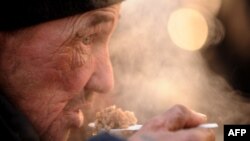 A homeless man eats hot food given out by the Emergency Situations Ministry in Moscow.