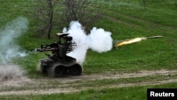 Украинские военнослужащие стреляют из гранатомета РПГ-7, установленного на беспилотном наземном роботизированном комплексе, во время испытаний на полигоне вблизи линии фронта. Запорожская область, 10 апреля 2026 года