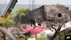 Ekipet duke larguar pjesë të një aeroplani të Air India, i cili u rrëzua të enjten, nga çatia e një ndërtese në Ahmedabad, Indi, 14 qershor 2025.