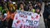 A Belgrade student hold a placard reading "Corruption kills, you have blood on your hands" as protesters gather outside the Supreme Public Prosecutor's Office on December 25 to demand accountability for the deadly rooftop collapse at the Novi Sad train station.