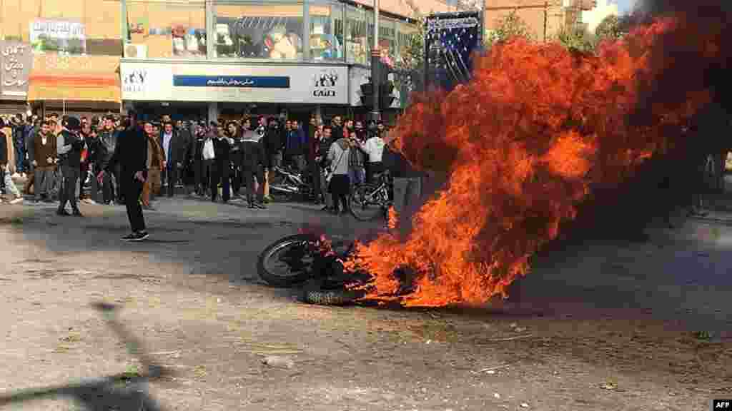 Iranian protesters gather around a burning motorcycle during a demonstration against an increase in gasoline prices in the central city of Isfahan on November 16. (AFP)