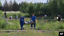 Russian law enforcement agents carry the body of former Transport Minister Roman Starovoit, who was found dead from a gunshot wound hours after his dismissal in Odintsovo, outside Moscow, on July 7.