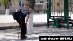 Awtobus duralgasyna tarap barýan ýaşuly adam.