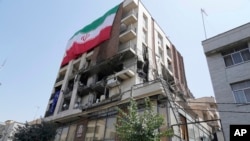 An Iranian flag hangs on a building which was hit by an Israeli strike in June.