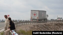 Vehicles of the International Committee of the Red Cross (ICRC) transporting humanitarian aid for residents of Nagorno-Karabakh drive towards the Armenia-Azerbaijan border along a road near the village of Kornidzor, Armenia, September 23, 2023.