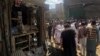 Residents gather near a damaged shop in a market after a blast in Parachinar, the capital of the Kurram tribal district on March 31.