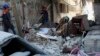 PALESTINE -- Workers inspect the rubble of the destroyed Abu Hussein building that was hit by an Israeli airstrike early morning, in Gaza City, Wednesday, May 19, 2021. (AP Photo/Adel Hana)