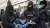 Kazakh police detain a man during a protest denouncing what opposition supporters called political repression in Almaty on February 28. (Reuters/Pavel Mikheyev)