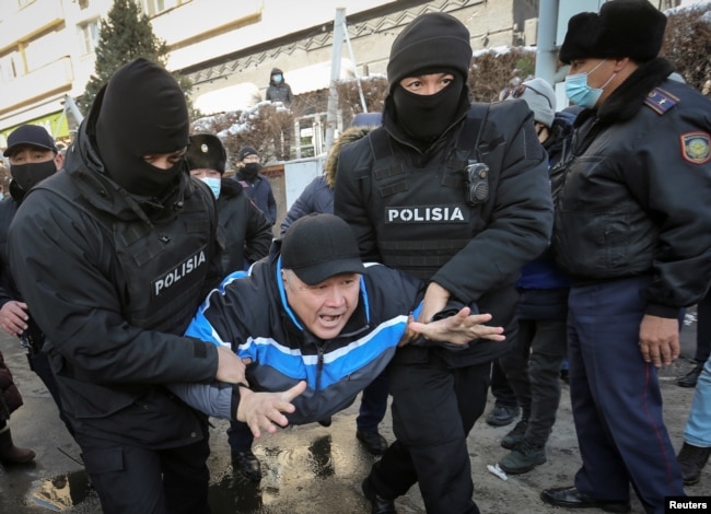 Полиция митинг өтетін жерге келген адамды ұстап әкетіп барады. Алматы, 28 ақпан 2021 жыл.