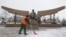 A worker removes snow in front of a statue of President Nursultan Nazarbaev in Almaty.