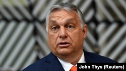 Hungarian Prime Minister Viktor Orban addresses the media as he arrives on the first day of the EU summit at the European Council building in Brussels on June 24.