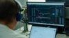 Un bărbat urmărește fluctuația cursului de schimb BTC (Bitcoin) - USDT pe una din platformele de tranzacționare a criptovalutelor. Imagine ilustrativă