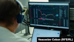 Un bărbat urmărește fluctuația cursului de schimb BTC (Bitcoin) - USDT pe una din platformele de tranzacționare a criptovalutelor. Imagine ilustrativă
