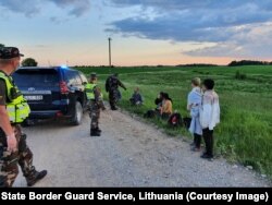 Lithuanian border guards detain a group of migrants on June 7.