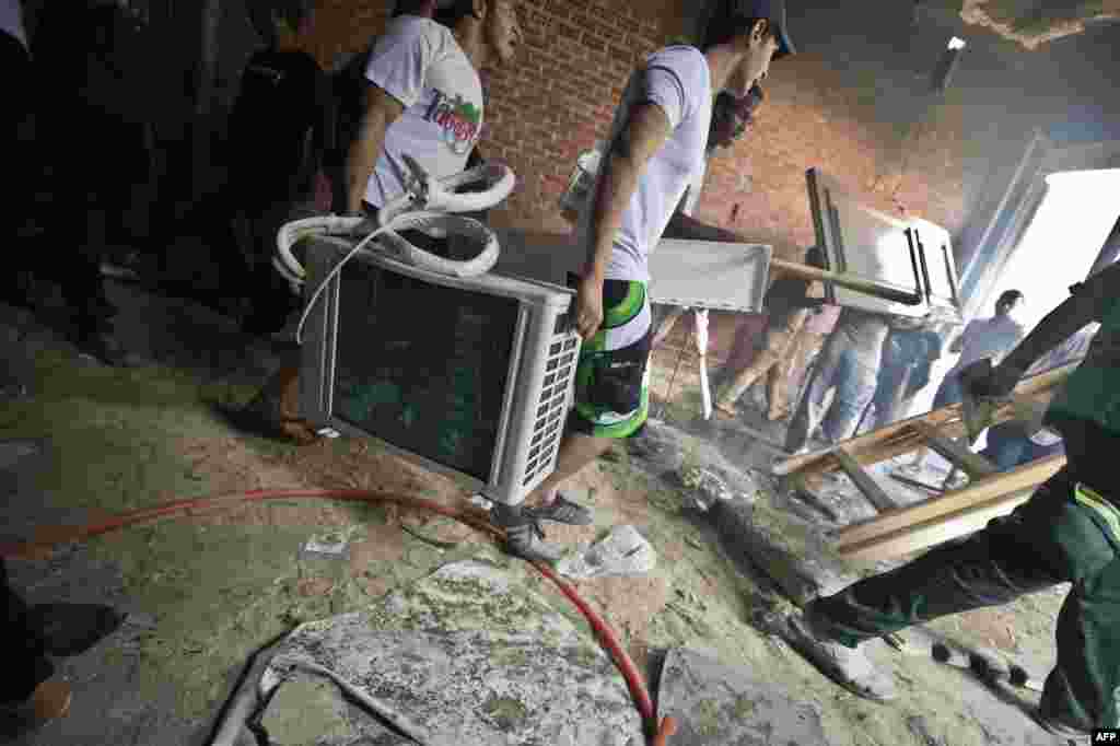 Men take equipment from the headquarters of the Muslim Brotherhood in the Moqattam district of Cairo.