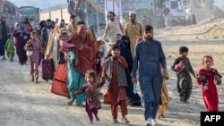 Afghan refugees in Pakistan walk toward the Torkham border crossing with Afghanistan on November 3, following Pakistan's decision to expel people illegally staying in the country.