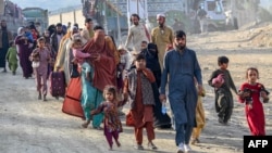 Afghan refugees in Pakistan walk towards the Pakistan-Afghanistan Torkham border crossing on November 3 following Pakistan's decision to expel people illegally staying in the country.