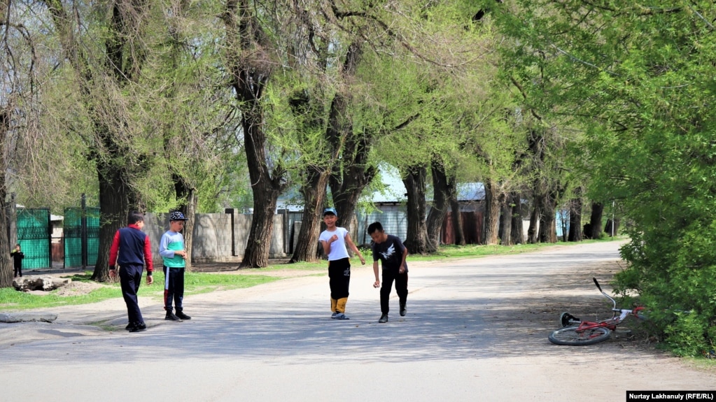 Дети Коктала играют в асык на дороге. Талгарский район, Алматинская область, 18 апреля 2021 года.