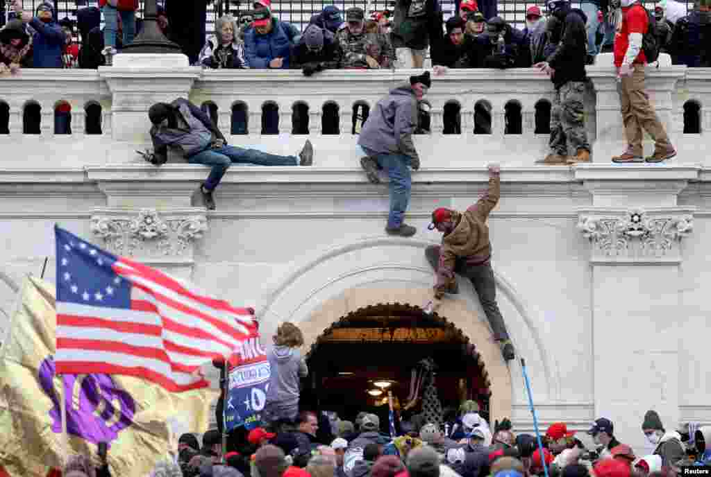 Прихильники Дональда Трампа штурмують будівлю Капітолію США, Вашингтон, округ Колумбія, 6 січня 2021 року. Дональд Трамп тоді був президентом США. Його прихильники вдерлися до будівлі конгресу після того, як Трамп, який програв вибори, виступив перед ними на мітингу неподалік Білого дому, заявивши, що результати виборів 2020 року були сфальсифіковані. Суди не підтвердили цього. Люди били шибки і вступали в сутички з поліцейськими. Законодавців терміново евакуювали. Внаслідок зіткнень загинули п&#39;ятеро людей, у тому числі співробітник поліції