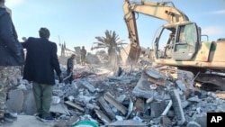 Members of Iraqi Shi'ite Popular Mobilization Forces clean up rubble after a U.S. air strike in Al-Qaim, Iraq, on February 3. 