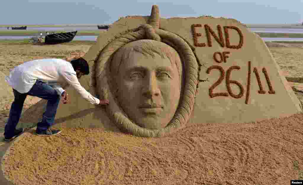 Indian sand artist Sudarshan Patnaik gives the final touches to a sand sculpture of Mohammad Ajmal Kasab, the lone survivor of the Pakistan-based militant squad responsible for a rampage through Mumbai that killed 166 people who was secretly hanged, on a beach in the eastern Indian state of Odisha. (Reuters)