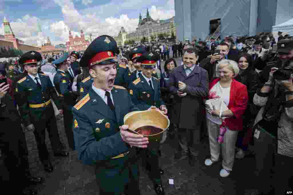 Graduates of the Moscow Military Commanders Training School drink sparkling wine from a helmet during their graduation ceremony in Red Square in Moscow. (AFP/Natalia Kolesnikova)